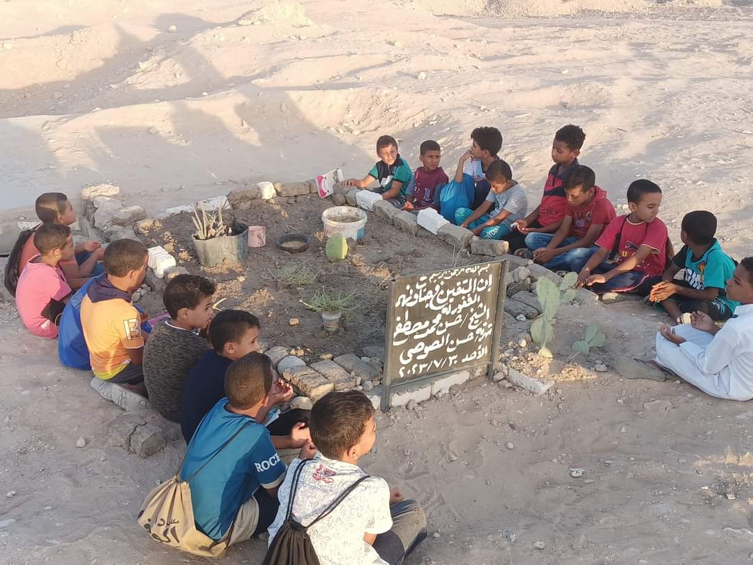 صغار يقرأون القرآن على قبر معلمهم1