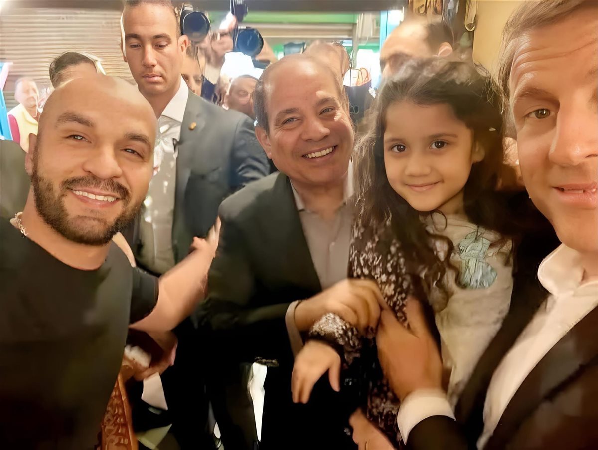 الرئيس الفرنسي يحمل طفلة مصرية بخان الخليلي&nbsp;