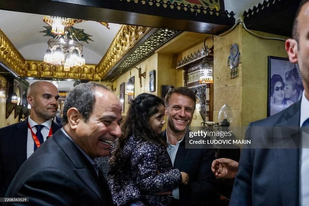 الرئيس الفرنسي يحمل طفلة مصرية بخان الخليلي&nbsp;