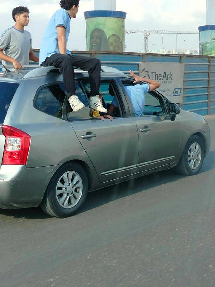 أطفال يستقلون سطح سيارة ملاكي بشارع التسعين في التجمع الخامس