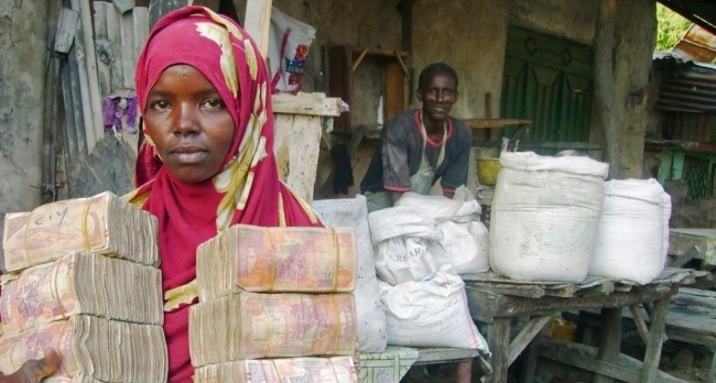 إمرأة صومالية تحمل نقودًا من فئة الشلن الصومالي&nbsp;