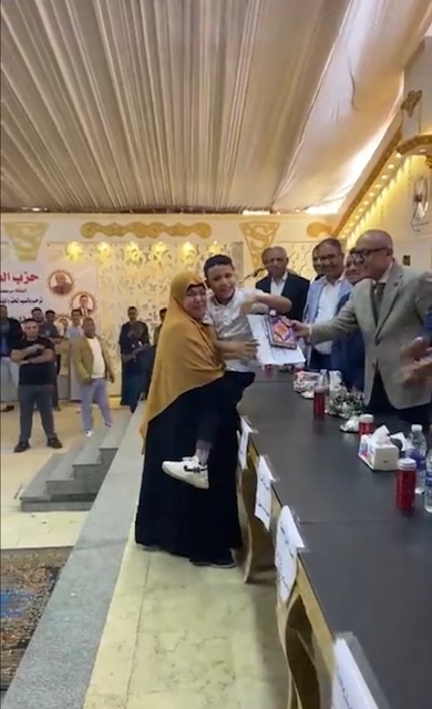 حملت إبنها على كتفها لتسلم تكريمة&nbsp;