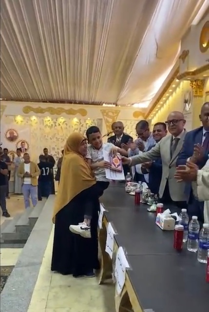 حملت إبنها على كتفها لتسلم تكريمة&nbsp;