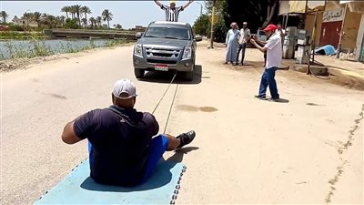 كابونجا ابن الإسماعيلية يستعد لسحب سيارة نقل 20 طنًّا وهو جالس على الأرض